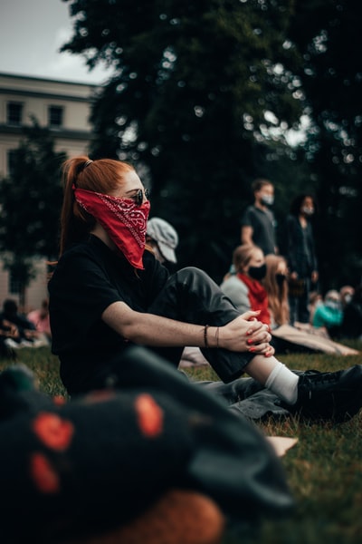 Women wear a black jacket, a red and white mask
